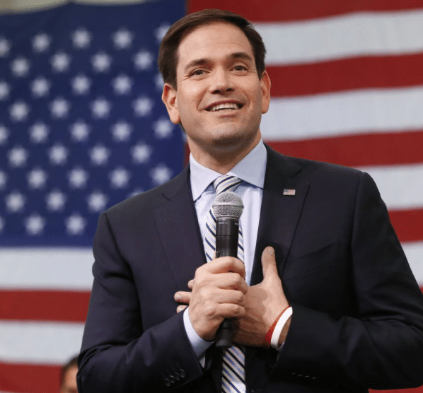 Marco Rubio smiling while speaking into a microphone.